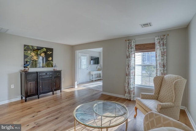 sitting room with visible vents, light wood-style flooring, and baseboards