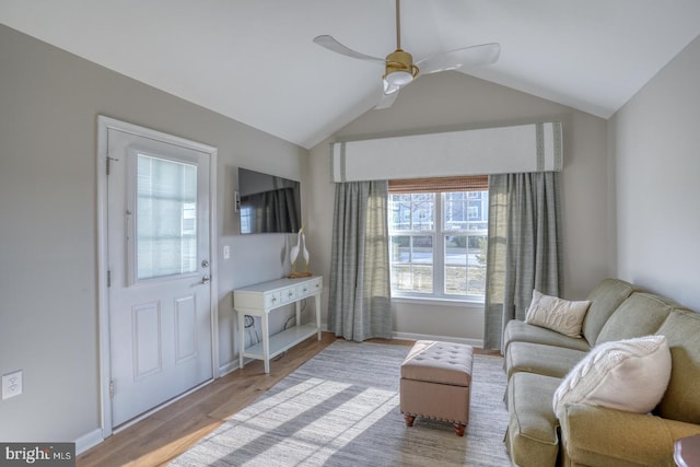 living area featuring vaulted ceiling, wood finished floors, baseboards, and ceiling fan