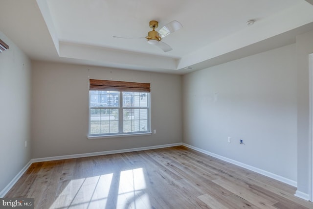 spare room featuring ceiling fan, baseboards, and wood finished floors