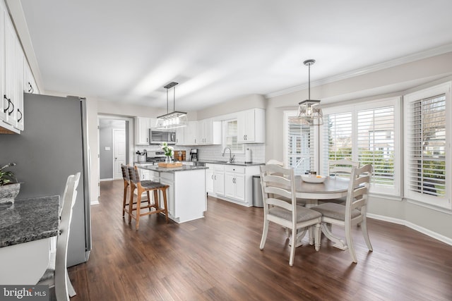 dining room with baseboards, an inviting chandelier, dark wood finished floors, and ornamental molding