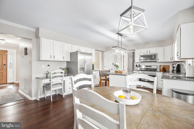 dining area with dark wood-type flooring, crown molding, baseboards, and visible vents