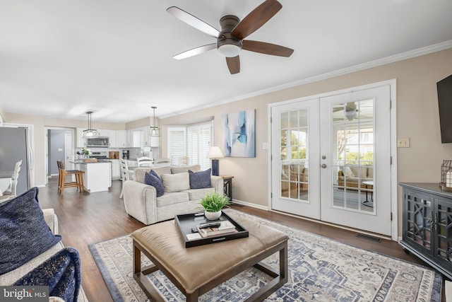 living area with french doors, dark wood finished floors, a ceiling fan, and crown molding