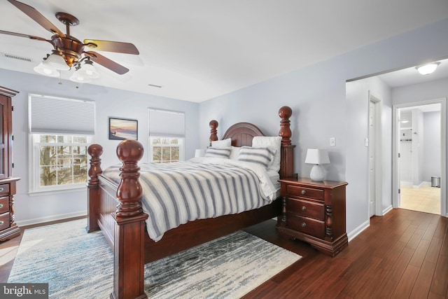 bedroom with multiple windows, baseboards, visible vents, and dark wood-style flooring