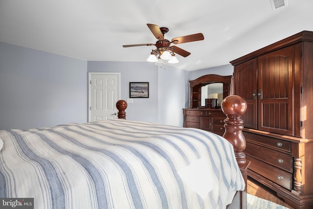 bedroom with ceiling fan, visible vents, and wood finished floors