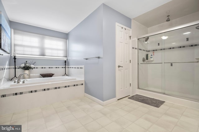 bathroom with baseboards, a garden tub, a shower stall, and tile patterned flooring