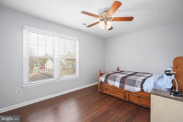 bedroom with visible vents, baseboards, wood finished floors, and a ceiling fan