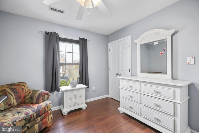 living area with a ceiling fan, dark wood-style floors, visible vents, and baseboards