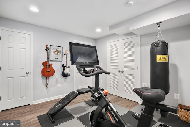 exercise area featuring recessed lighting, wood finished floors, and baseboards