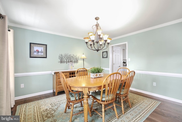 dining space with baseboards, an inviting chandelier, and wood finished floors