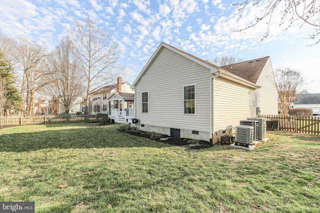 view of side of property with a fenced backyard, crawl space, and a yard