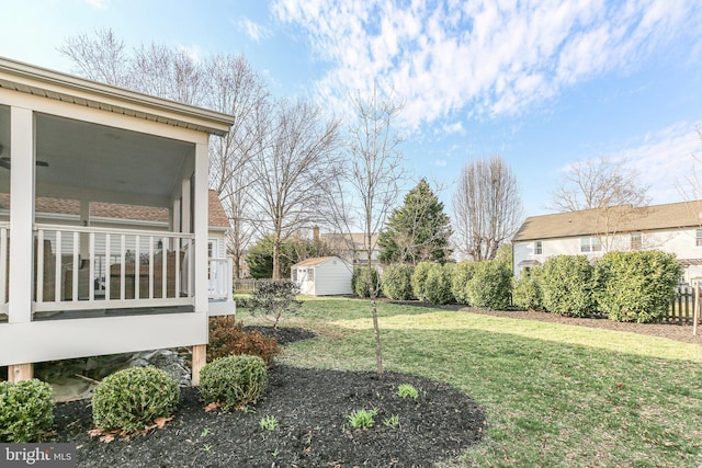 view of yard with a shed, fence, an outdoor structure, and a sunroom