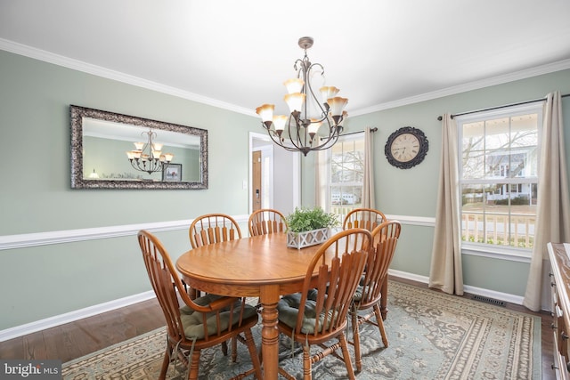 dining space featuring crown molding, wood finished floors, baseboards, and a chandelier