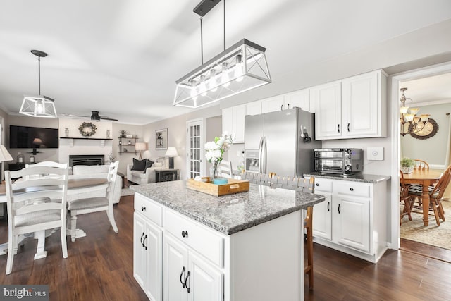 kitchen featuring a kitchen island, dark wood finished floors, stainless steel refrigerator with ice dispenser, white cabinetry, and decorative light fixtures