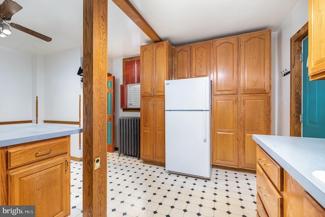 kitchen with a ceiling fan, light floors, radiator heating unit, freestanding refrigerator, and light countertops