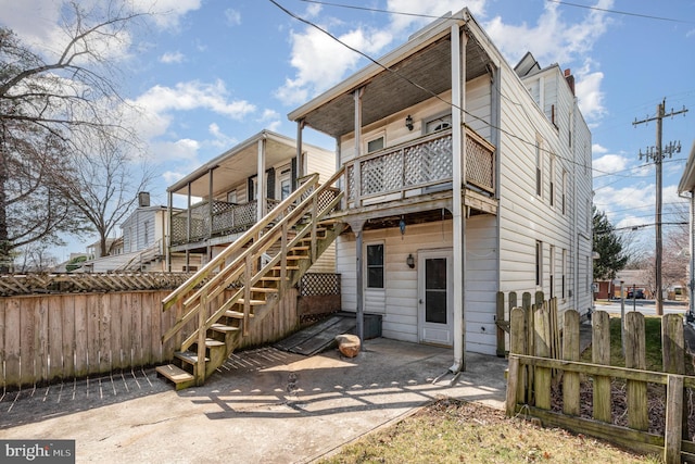 rear view of property with stairs and fence