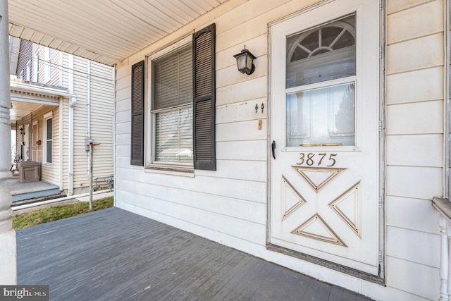 view of exterior entry featuring covered porch