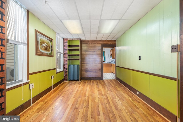 spare room with a drop ceiling and wood finished floors