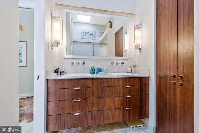 bathroom featuring double vanity, backsplash, and a sink