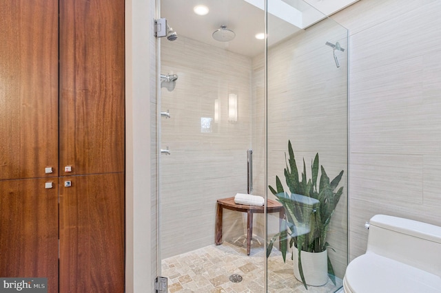 full bath featuring tile walls, a skylight, toilet, and tiled shower