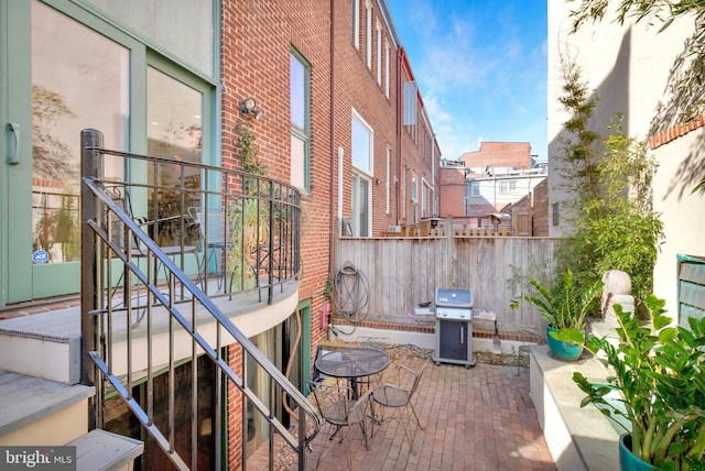 view of patio with area for grilling and fence