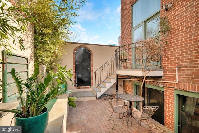 doorway to property with brick siding and a patio