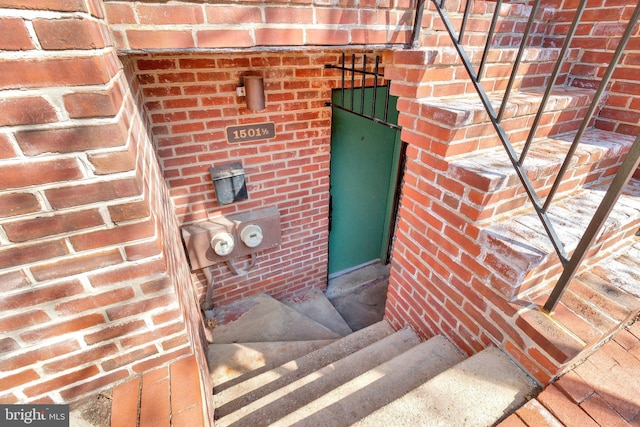 view of exterior entry featuring brick siding