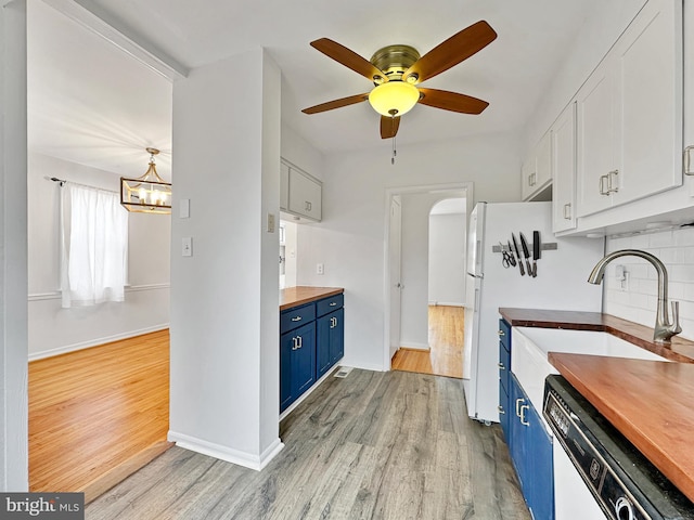 kitchen with blue cabinetry, butcher block countertops, dishwasher, light wood-type flooring, and a sink