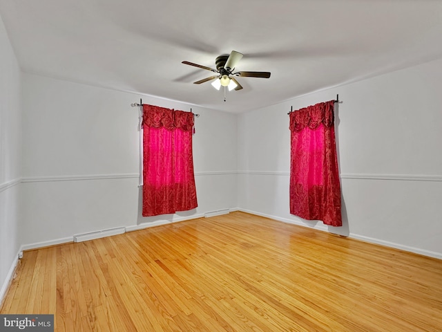 empty room with visible vents, baseboards, ceiling fan, and wood finished floors