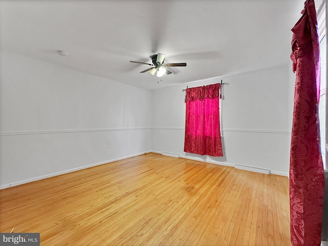 empty room featuring visible vents, baseboards, a ceiling fan, and wood finished floors