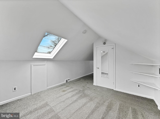 additional living space featuring lofted ceiling with skylight, baseboards, visible vents, and carpet floors