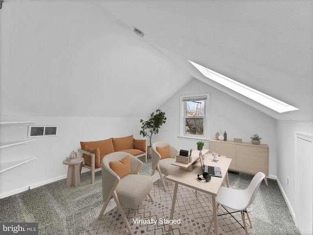 sitting room featuring visible vents, vaulted ceiling with skylight, baseboards, and carpet floors