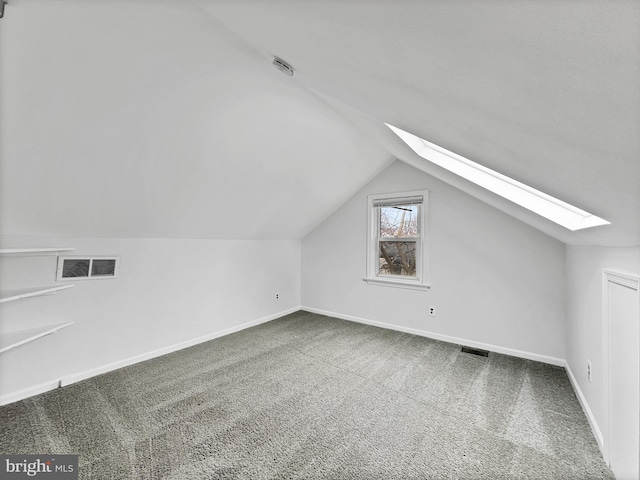 bonus room with visible vents, vaulted ceiling with skylight, baseboards, and carpet floors