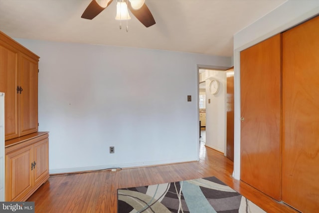 unfurnished living room with baseboards, wood finished floors, and ceiling fan