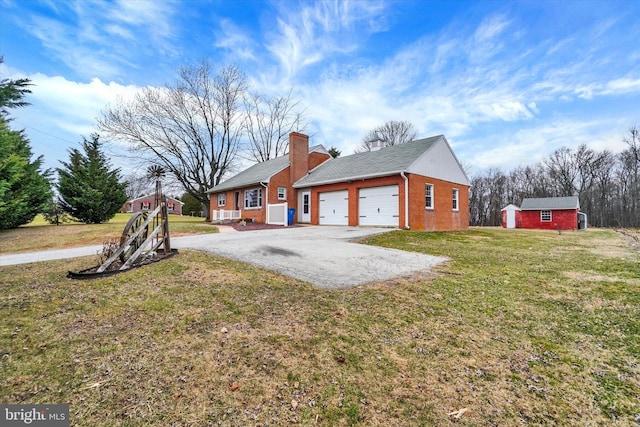 view of side of home featuring a lawn, aphalt driveway, an attached garage, brick siding, and a chimney