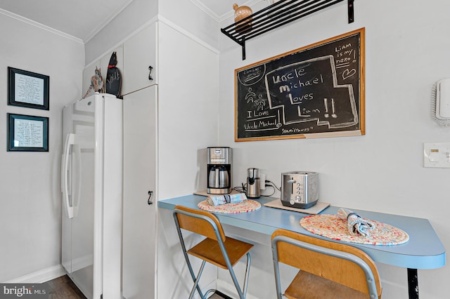 interior space featuring crown molding, baseboards, and wood finished floors