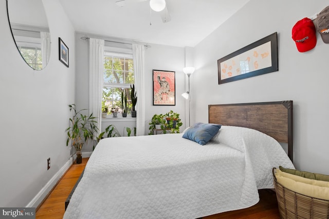 bedroom with baseboards, a ceiling fan, and wood finished floors