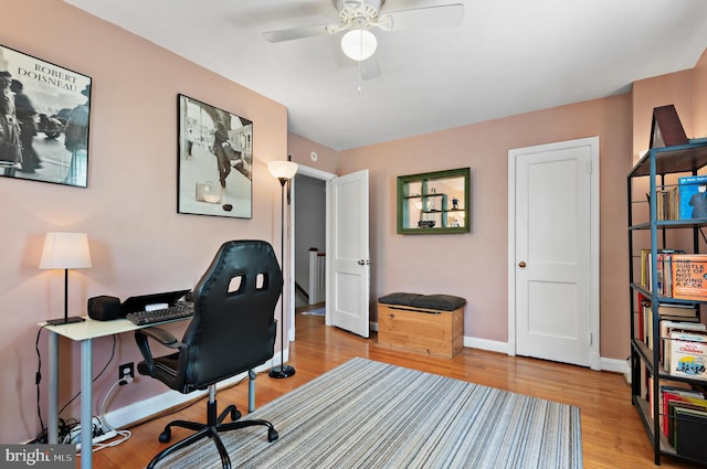 office space with baseboards, a ceiling fan, and wood finished floors