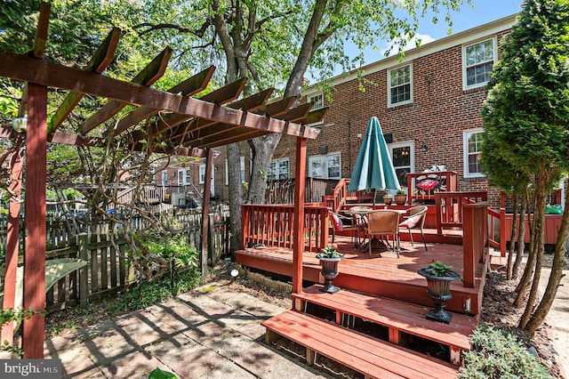 wooden terrace featuring fence, a pergola, and outdoor dining space