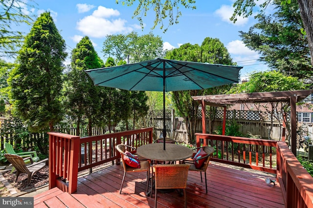 wooden deck featuring a pergola, outdoor dining area, and a fenced backyard