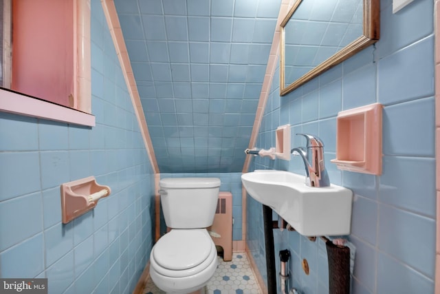 bathroom featuring tile walls, radiator, toilet, and a sink