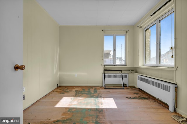 empty room featuring light wood-type flooring and radiator