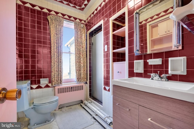 bathroom featuring toilet, tile walls, radiator, and vanity