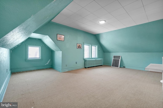 additional living space with lofted ceiling, radiator, and carpet flooring