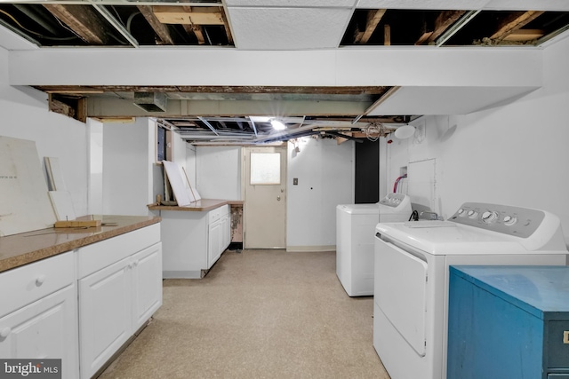 laundry room featuring washer and dryer, cabinet space, and light floors