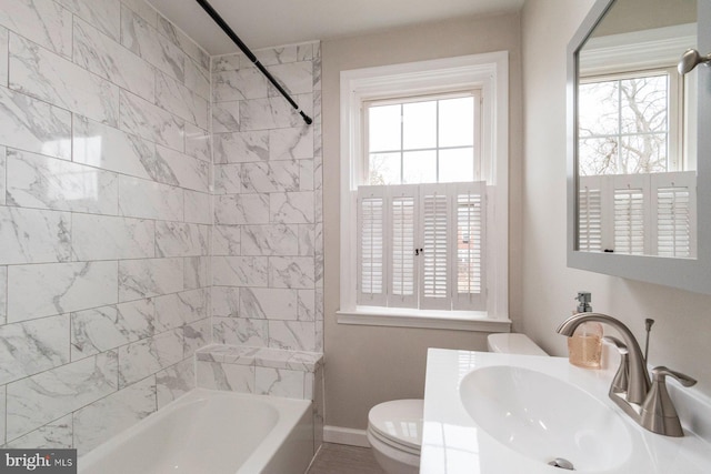 bathroom featuring shower / tub combination, toilet, baseboards, and a sink