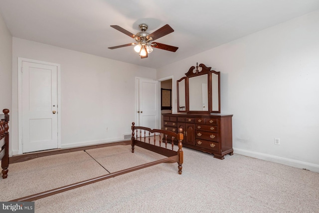 bedroom featuring light carpet, visible vents, a ceiling fan, and baseboards