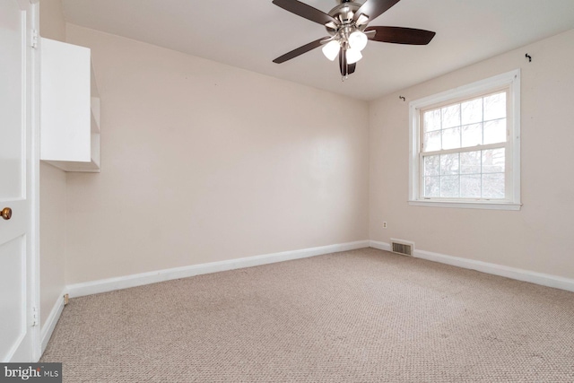 empty room with light carpet, visible vents, ceiling fan, and baseboards