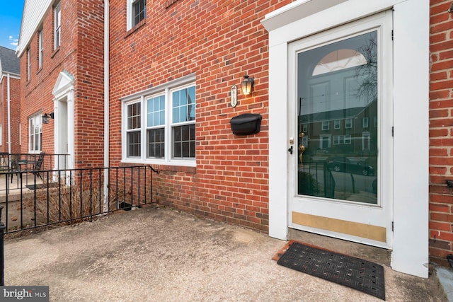 view of exterior entry featuring brick siding