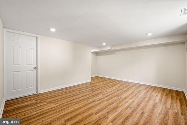 finished basement featuring recessed lighting, light wood-style flooring, visible vents, and baseboards