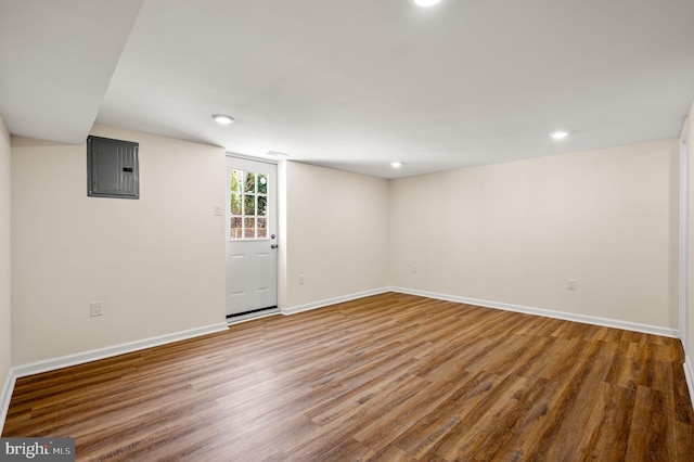 below grade area featuring electric panel, recessed lighting, baseboards, and wood finished floors